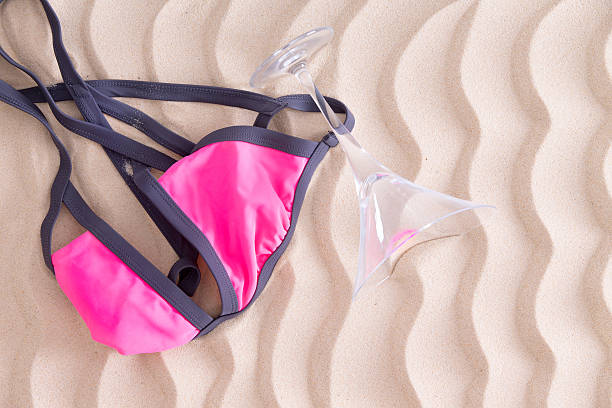istock Fun pink bikini top and martini glass on the beach 599764064
