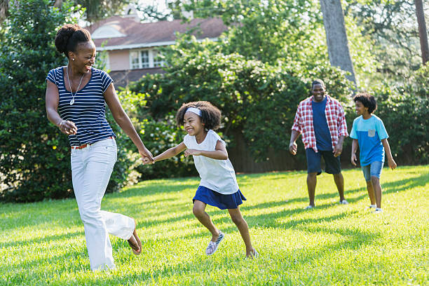 familia con raza mixta jugar de los niños al aire libre, a unos - couple mature adult action walking fotografías e imágenes de stock