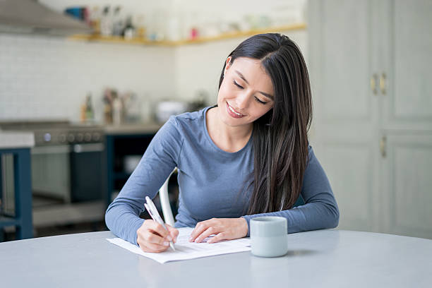 Casual Woman At Home Writing On Documents Stock Photo - Download Image Now  - Writing - Activity, Letter - Document, Women - iStock