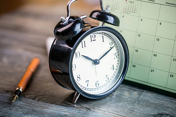 istock alarm clock and calendar on wooden table 599768228