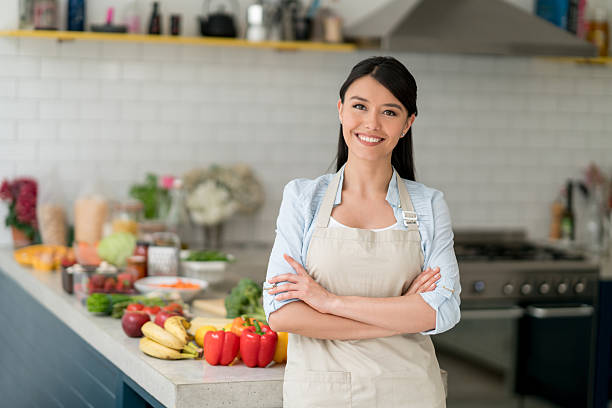 happy woman cooking at home - estereótipo de dona de casa imagens e fotografias de stock