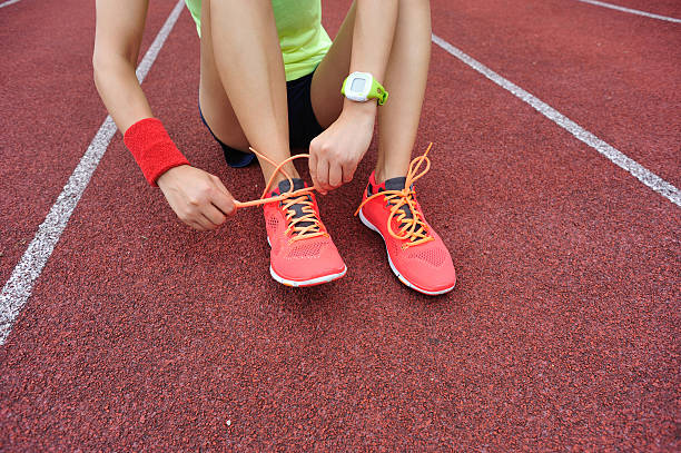 istock young woman runner tying shoelaces on tracks 599773610
