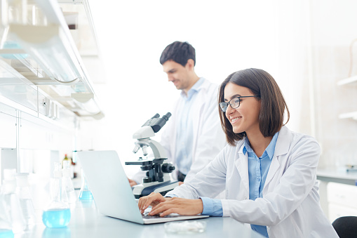 Happy scientist working with electronic data in lab