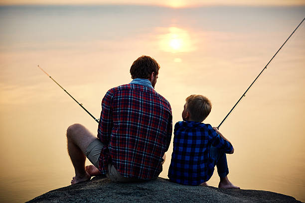 pêche en soirée - fishing father son family photos et images de collection