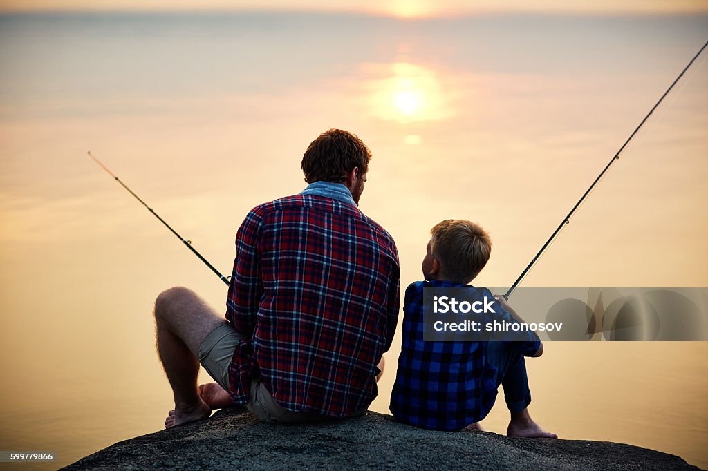 Evening fishing Father and son fishing at sunset Father Stock Photo
