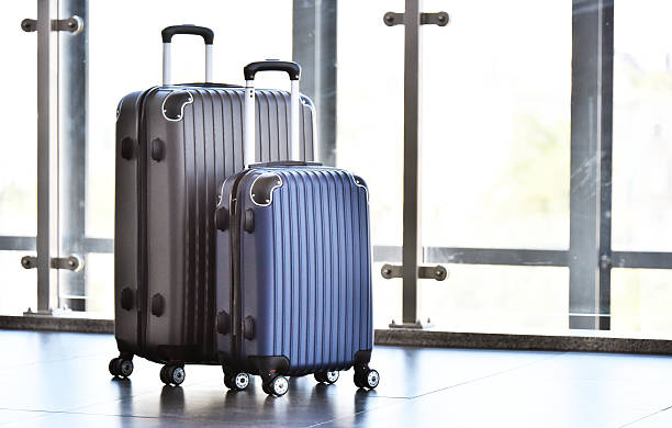istock Two plastic travel suitcases in the airport hall 599780628