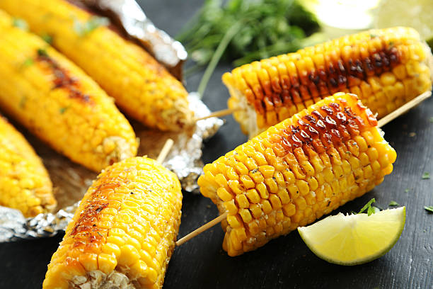 istock Tasty grilled corn on black wooden table 599781592