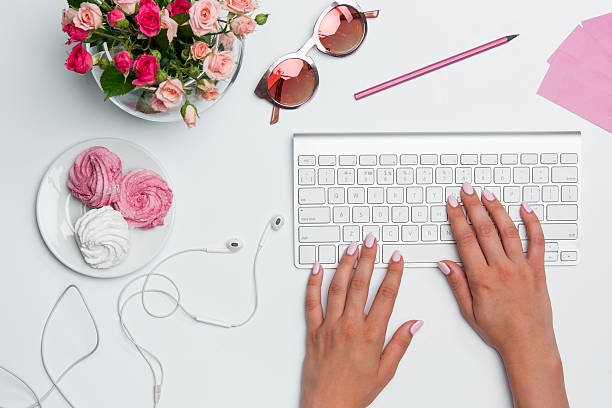 istock Office desk table with female hands, computer, supplies, flowers 599783674