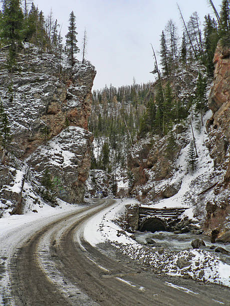 istock Winter road between the mountains with forest and snow 599783808