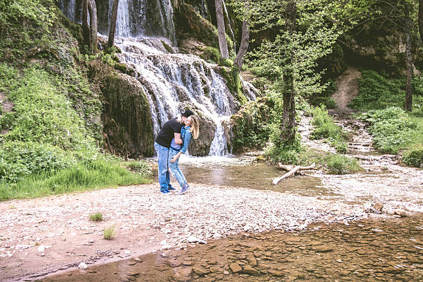istock Happy young couple in front of waterfall. 599784868