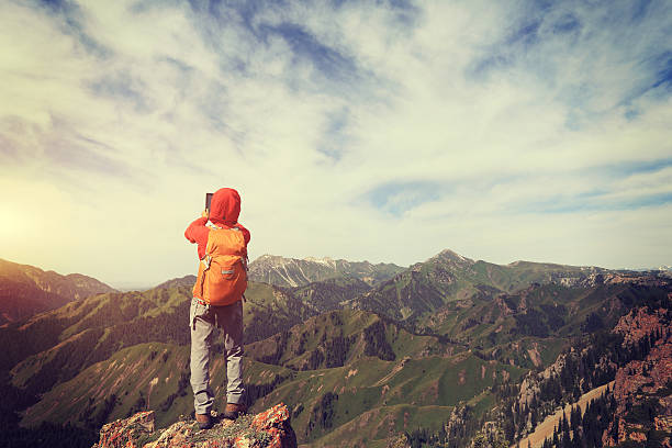 istock woman backpacker use digital tablet taking photo on mountain peak 599784966