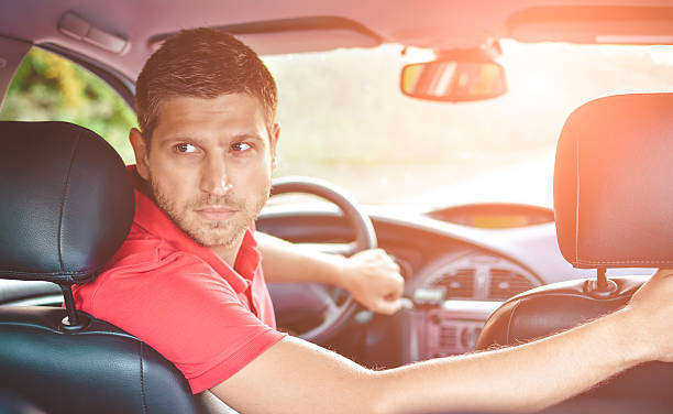 beau conducteur d’homme regardant en arrière et parking voiture - car driving men reversing photos et images de collection