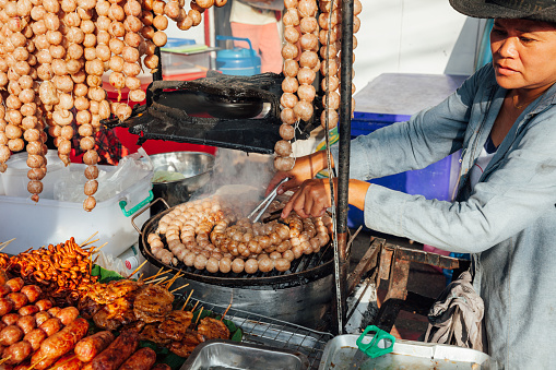 Chiang Mai, Thailand - August 21, 2016: Thai woman cooks meatballs at the Sunday Market (Walking Street).