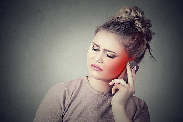 istock woman talking on mobile phone having pain headache 599789904