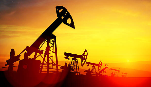 istock 3d illustration of oil pump jacks on sunset background 599790944