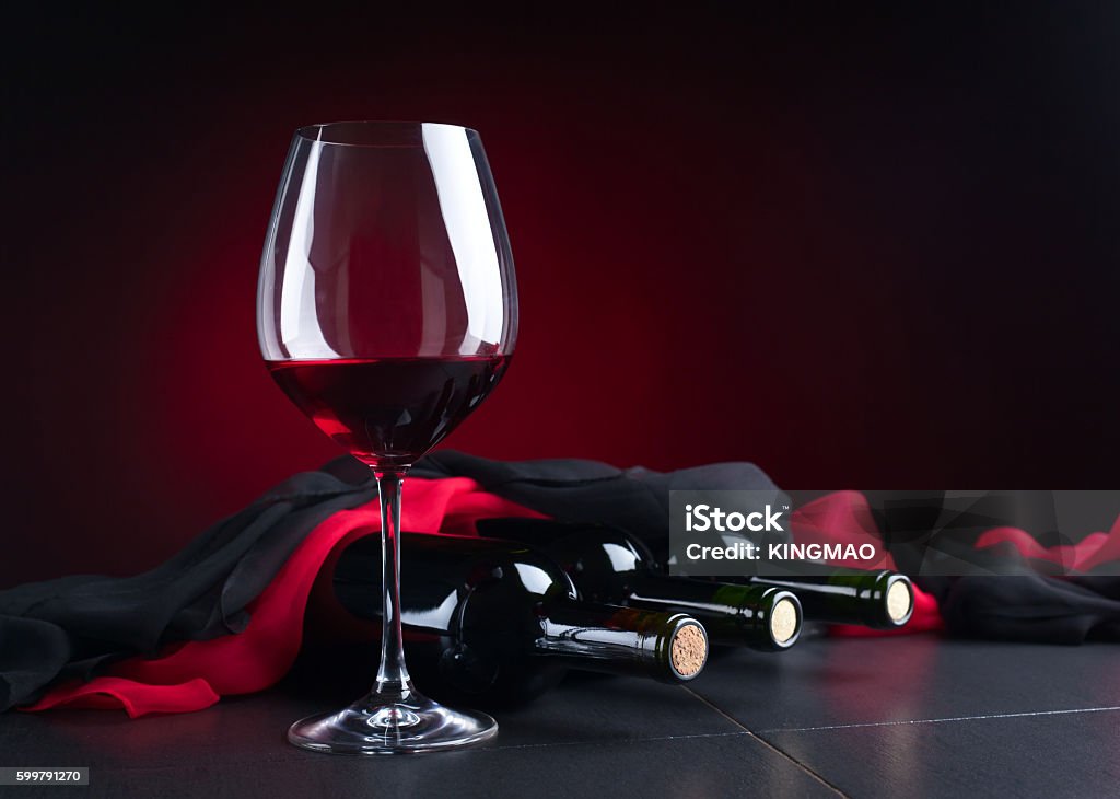 bottles and glass of red wine bottles and glass of red wine on  black table Alcohol - Drink Stock Photo