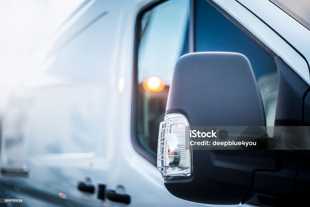 white van side view mirror close up (street shot) at dusk of a new white van with focus on the side view mirror. More service vehicles and cars in my portfolio. Van - Vehicle Stock Photo