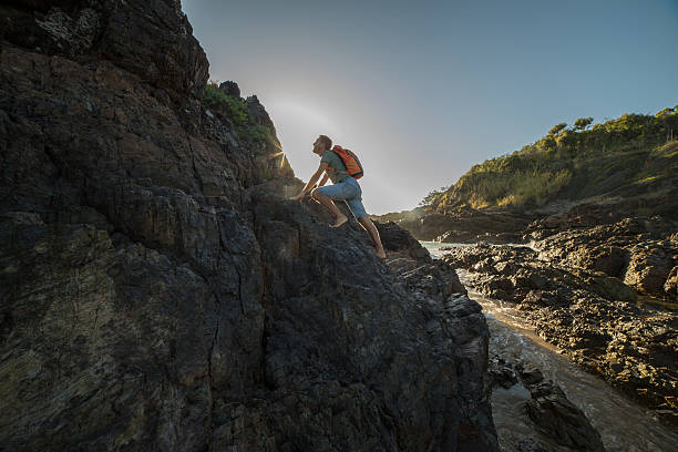 istock Caucasian male climbs steep rock, towards sunlight 599793722