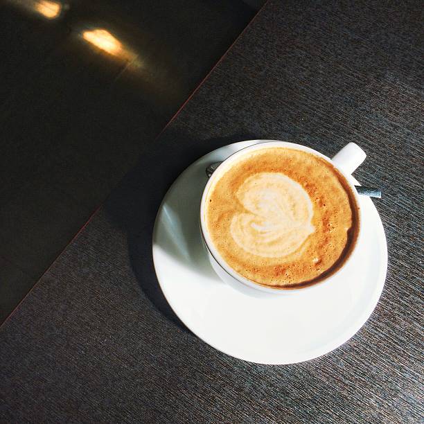 One cappuccino on dark brown table