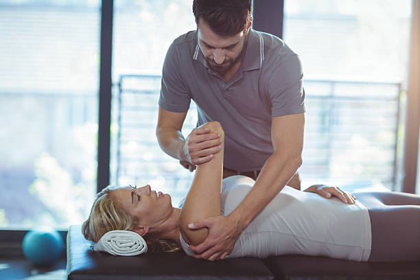 istock Physiotherapist giving shoulder therapy to a woman 599867838