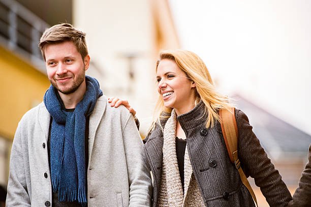 Young woman and man on a walk in town Beautiful young woman and man on a walk in town, talking and laughing teenager couple child blond hair stock pictures, royalty-free photos & images