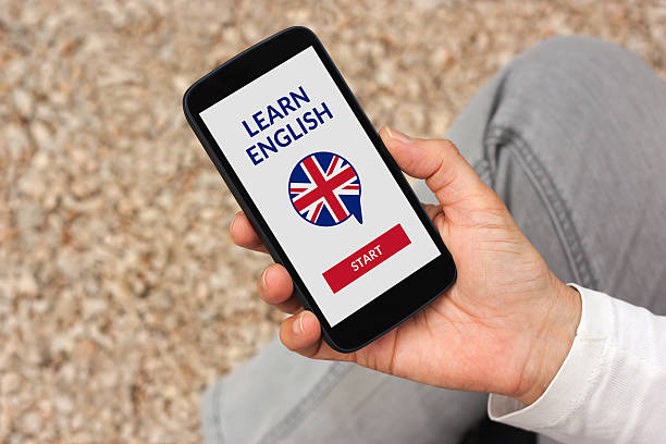istock Hand holding smartphone with online learn English concept on screen 599869624