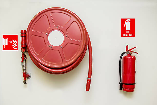 Fire and Safety Fire hose reel and fire extinguisher with signs fire hose photos stock pictures, royalty-free photos & images
