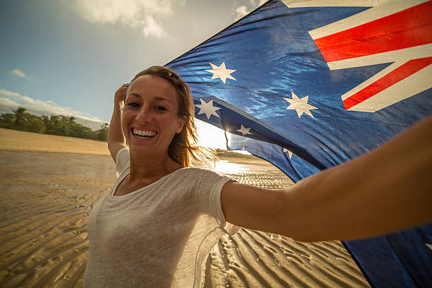 istock Student holding Australian flag on beach 599870696