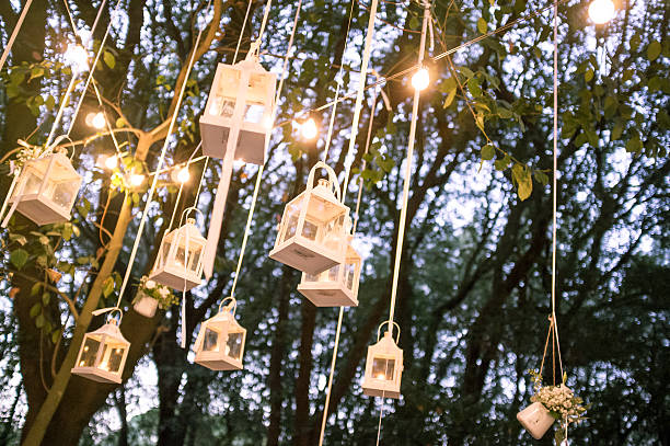 istock Light bulbs and lanterns in oak forest at sunset 599872404