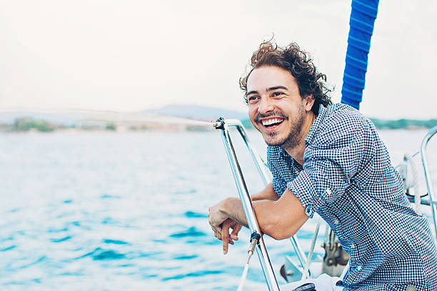 istock Smiling young man on an yacht 599872572