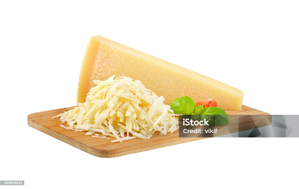 grated parmesan cheese grated parmesan cheese on wooden cutting board Grated Stock Photo