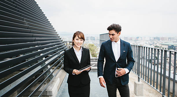 istock Two Asian Business Partners Walking on a Rooftop 599877952