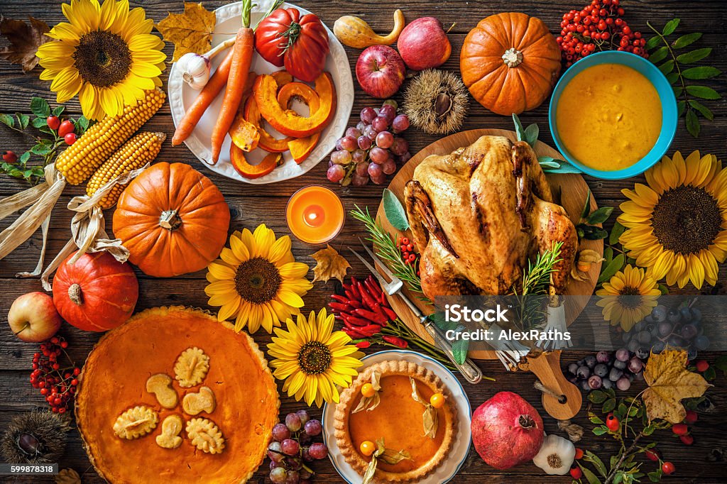 Roasted Thanksgiving Turkey Thanksgiving dinner. Roasted turkey with pumpkins and sunflowers on wooden table Thanksgiving - Holiday Stock Photo