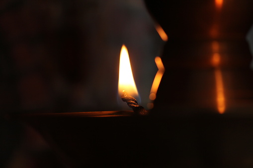 Close-up of a burning wick in a traditional Kerala style brass lamp. Kerala lamp is known as nilavilakku or vilakku lights up the darkness.