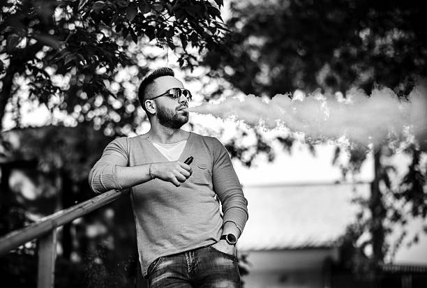 istock Vaper with beard in sunglasses vaping outdoor 599884966