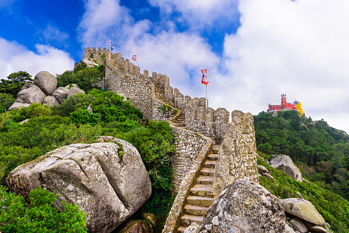 Sintra, Portugal - October 17, 2014: Castle of the Moors outer wall with Pena National Palace in the distance. The castle construction dates from the 8th and 9th centuries.