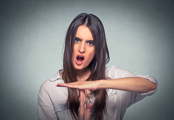 Woman showing time out hand gesture screaming Young woman showing time out hand gesture, frustrated screaming to stop isolated on gray background. Human emotions face expression reaction time out signal stock pictures, royalty-free photos & images