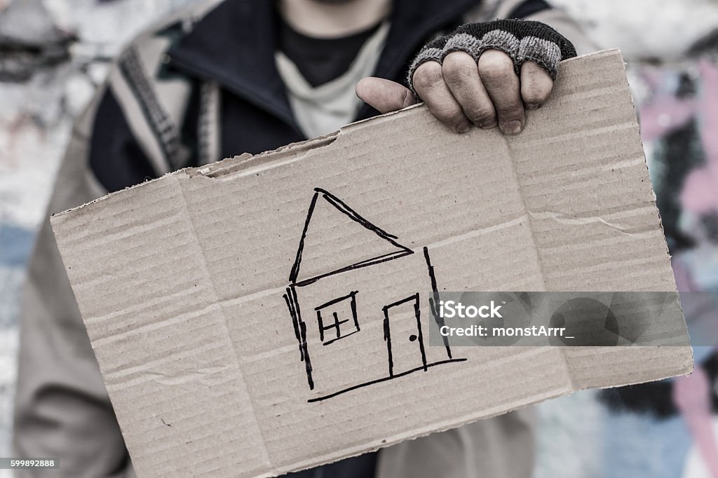 Praying for home Young homeless man holding sign with painted house Despair Stock Photo