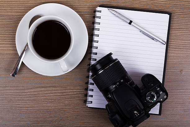 istock Coffee cup and camera on a wooden surface 599893124