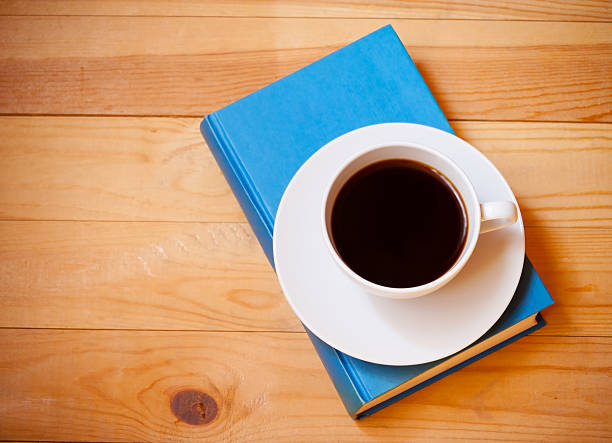 istock Coffee cup and book on wooden  background. Top view 599893174