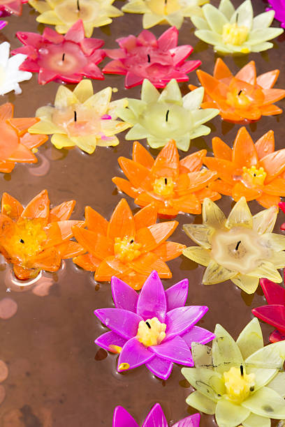 istock Colorful candle in lotus shape floating on water 599894036