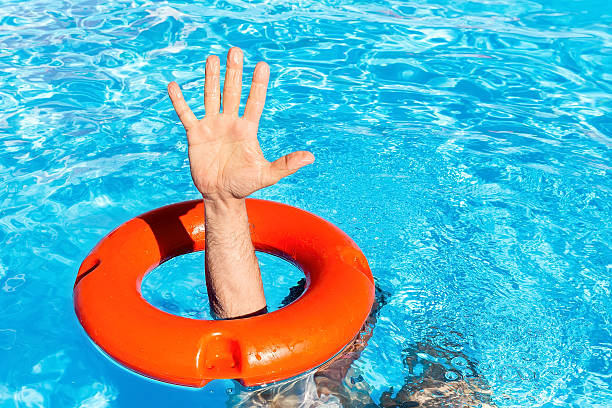 istock Arm through orange buoy in swimming pool 599895086
