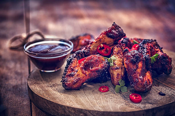 Homemade spicy chicken wings with chili served with dip.