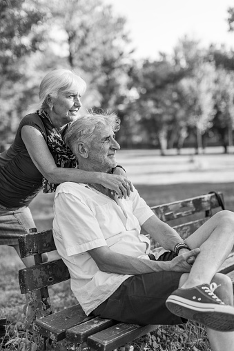 An old couple together in the park hugging