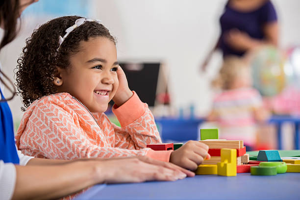 istock Girl plays with blocks in preschool class 599899932