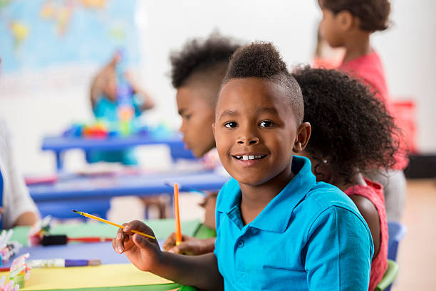 istock Handsome boy works on art project at school 599899972