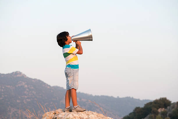 young boy shouting in megaphone - marketing megaphone child using voice imagens e fotografias de stock