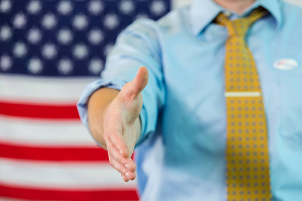 istock Hand ready to shake in front of American flag 599901588