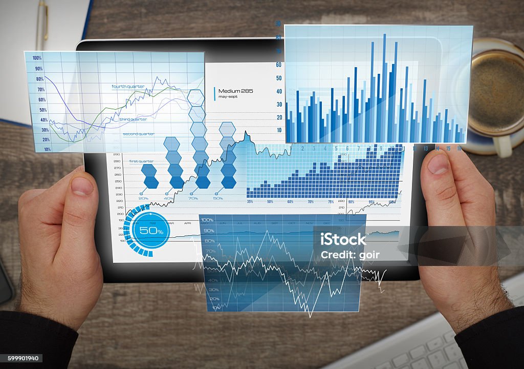 Financial future analyzing Man using a digital tablet at desk Data Stock Photo