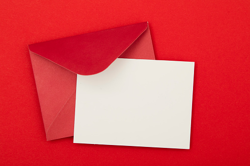 Blank invitation card with a red envelope on a red background